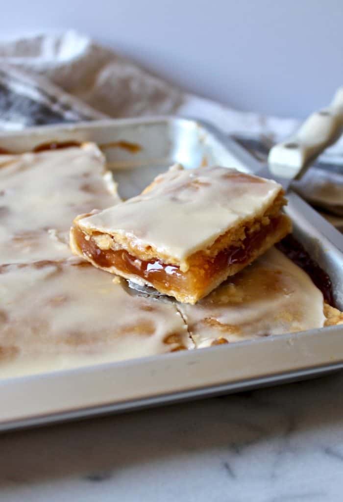 Apple slice on serving knife over sheet pan