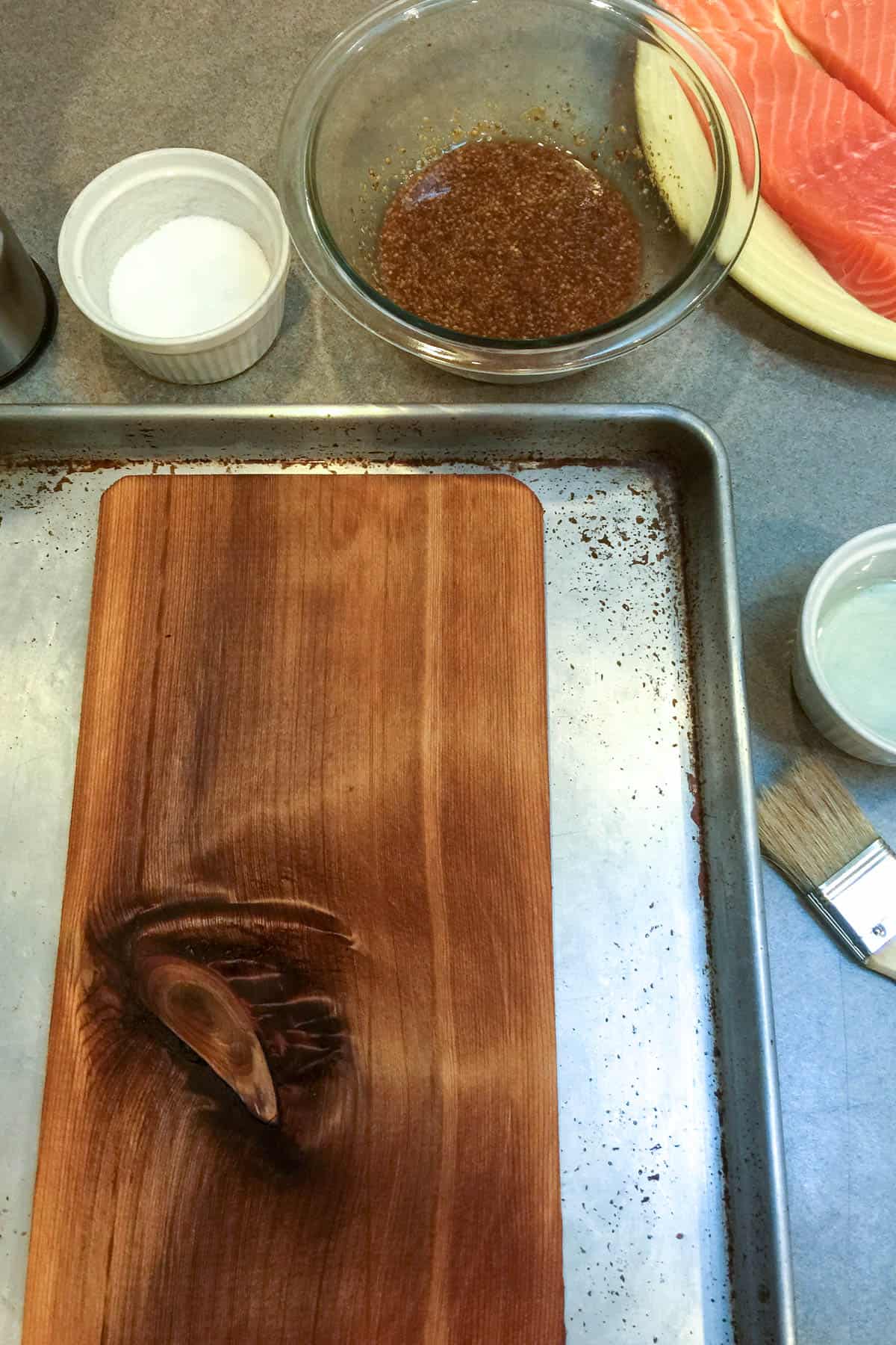 Soaked cedar plank on sheet pan ready for grill