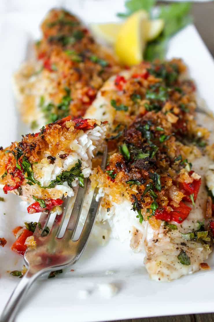 Greek fish on platter with forkful.