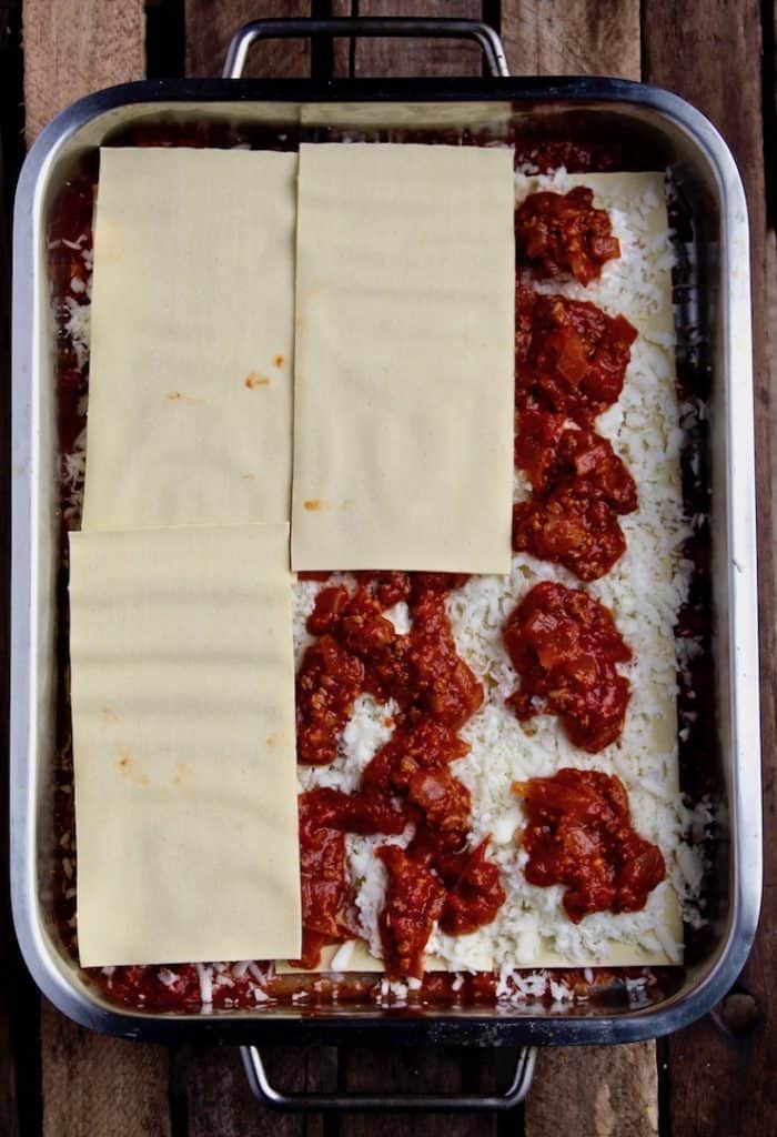Process photo showing layering of lasagna in pan