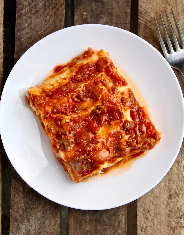 Piece of lasagna on white plate.