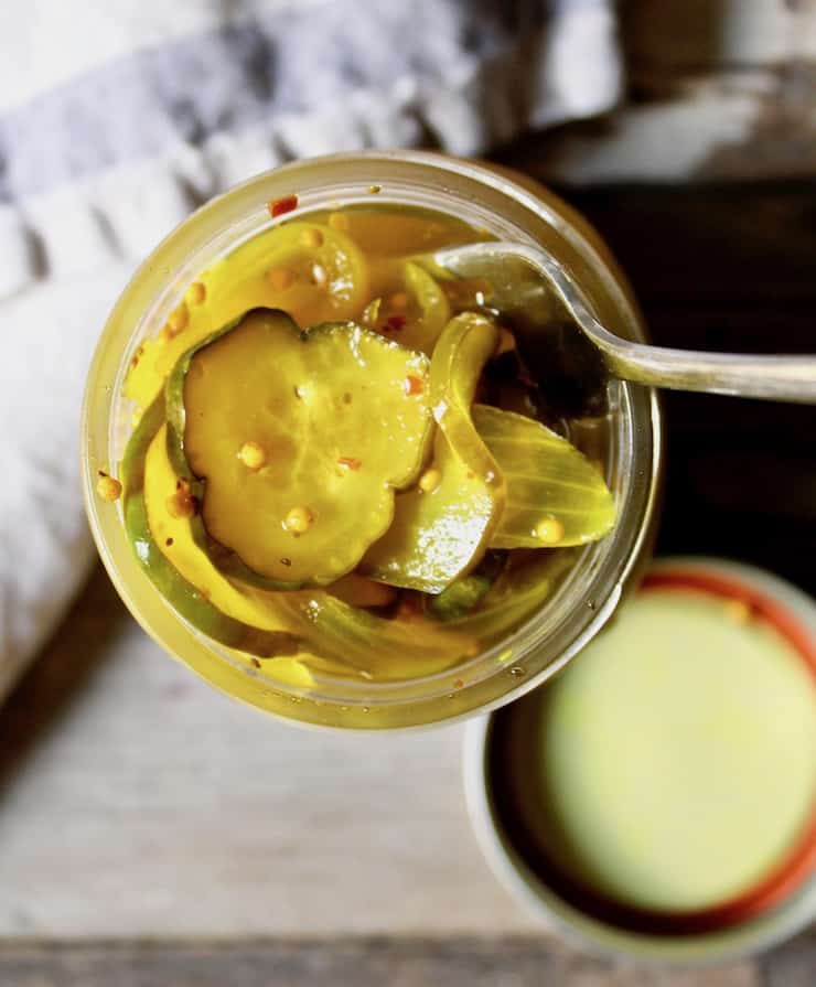 Overhead of jars of pickles with fork inserted into it.