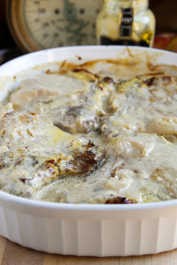 Pork chops and apples in baking dish.