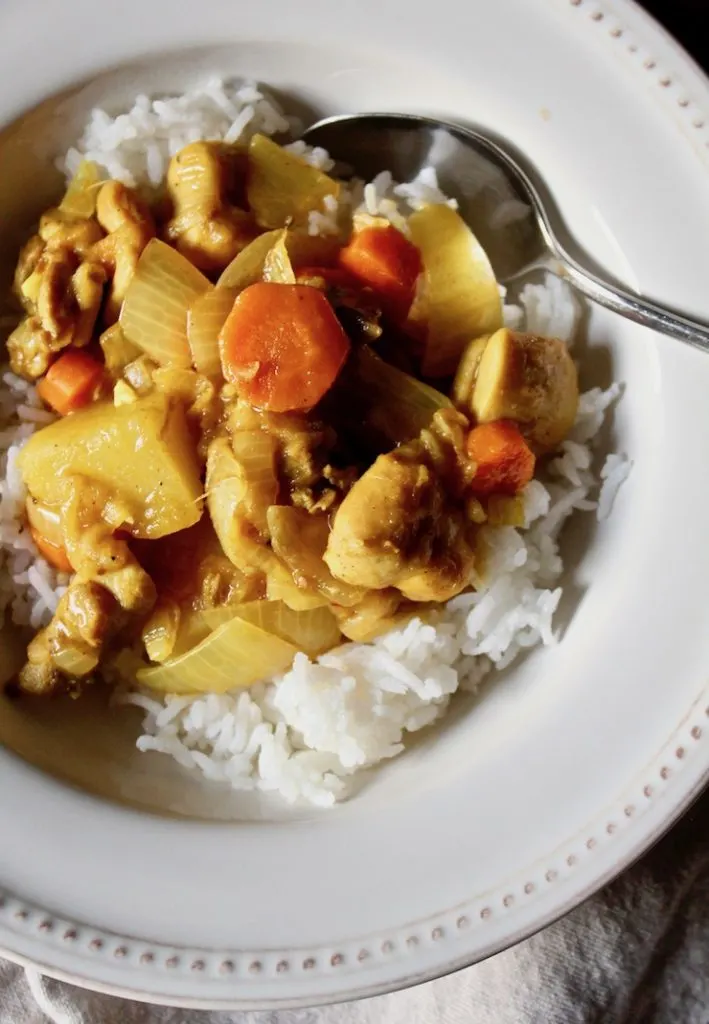 Close up of chicken curry in bowl with spoon.