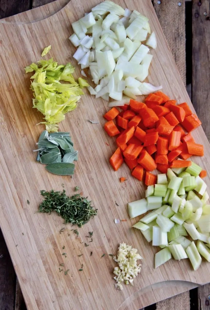 Cutting and prepping veggies and herbs on board.