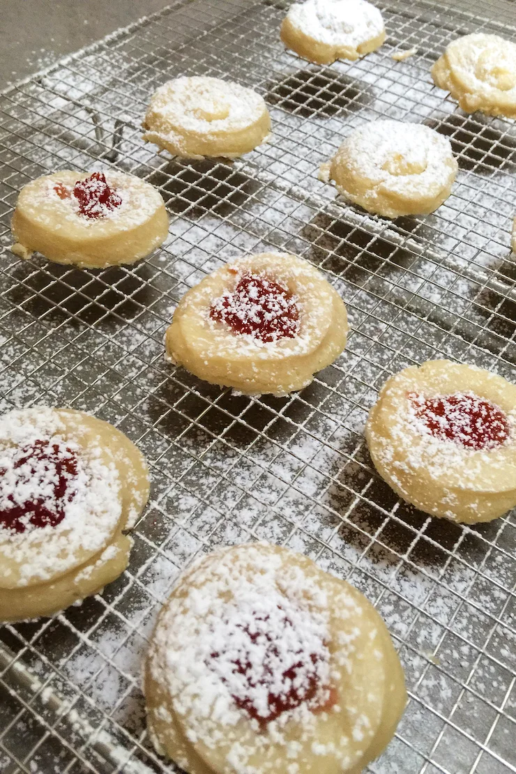 Dusting with powdered sugar while warm on rack