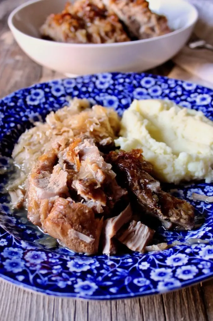 Braised Pork and Sauerkraut, on plate with serving bowl in background