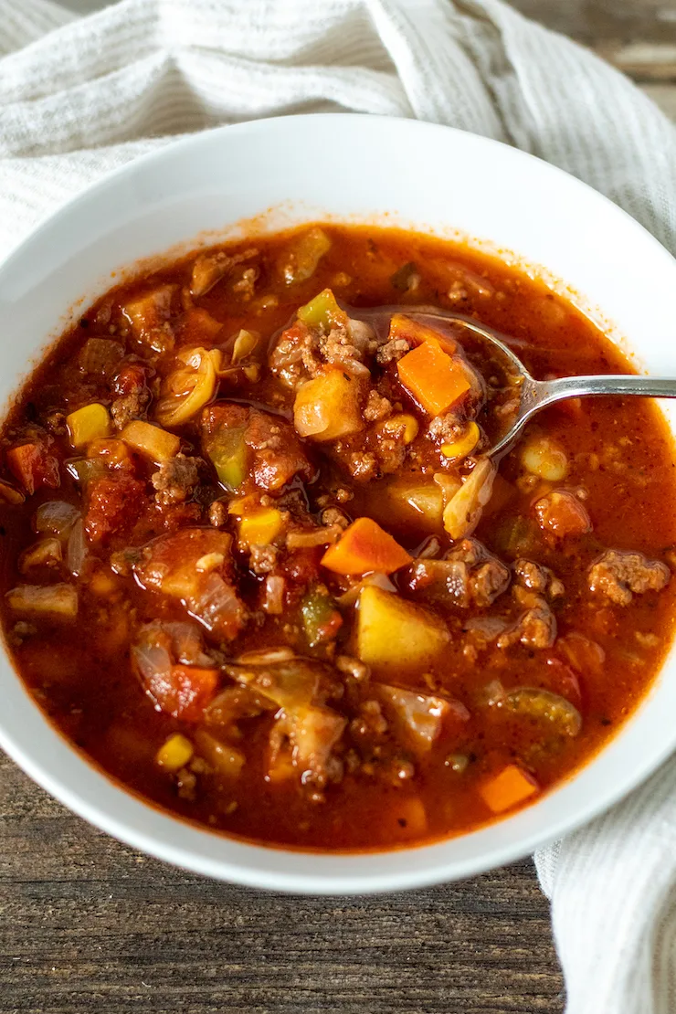 Vegetable beef soup in serving bowl with spoon.