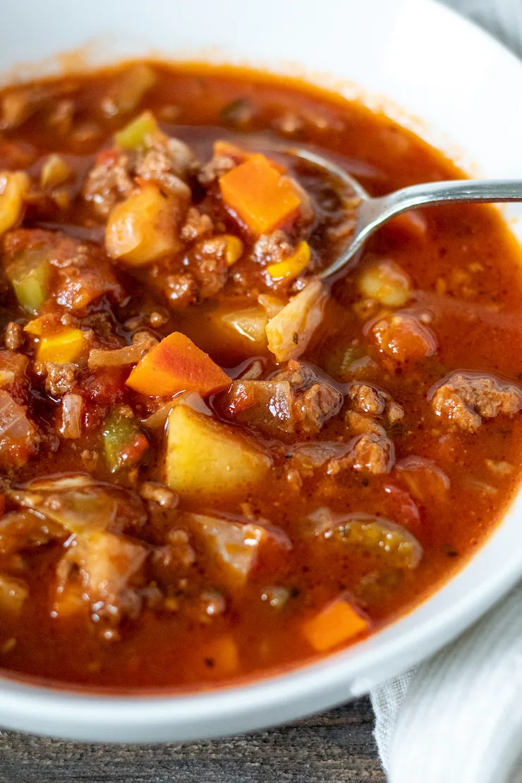 Close up of soup in bowl with spoon.