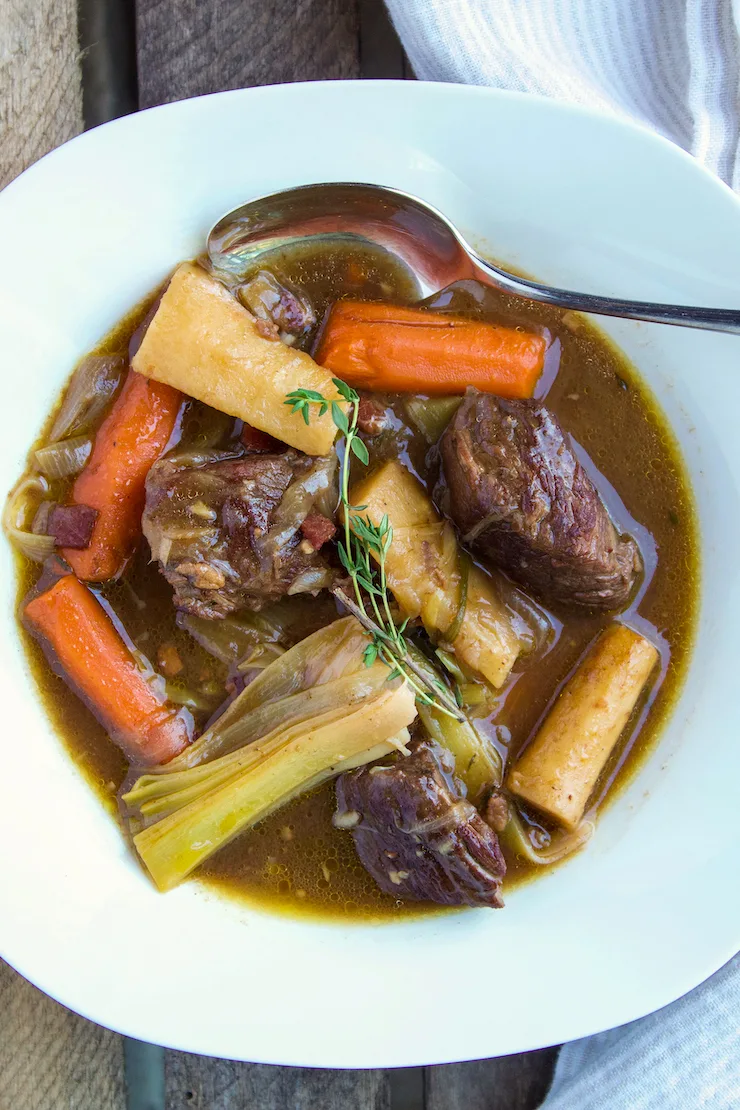 Beef stew in serving bowl with spoon.