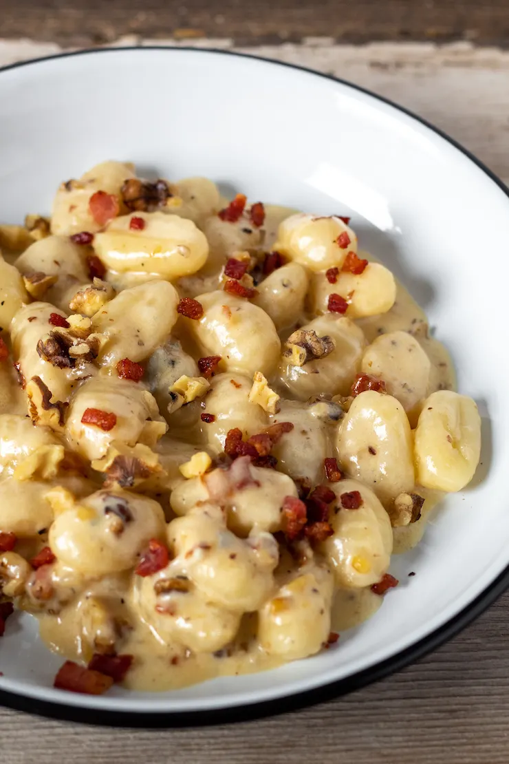 Close up of gnocchi gorgonzola in serving dish.