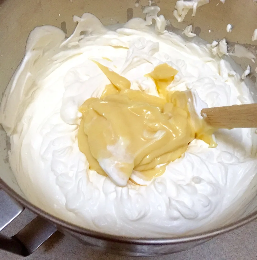 Éclair Cake, folding pudding mixture into whipped cream.
