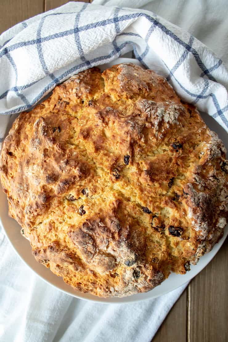 Round loaf of soda bread on serving plate.