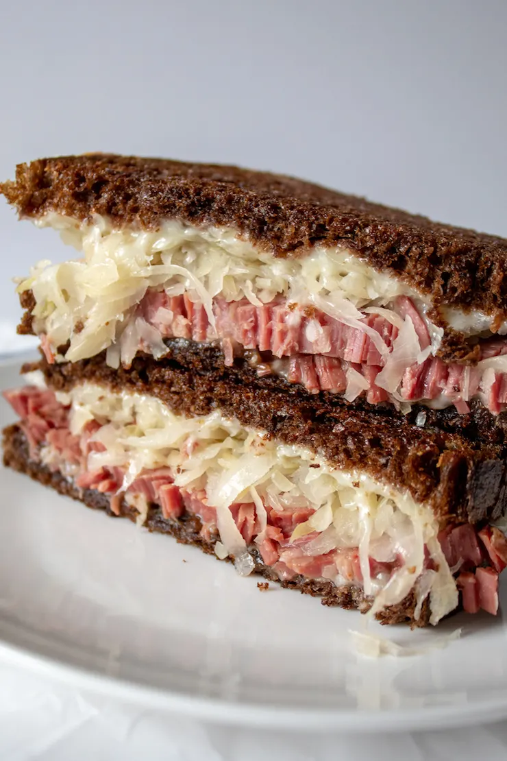 Reubens, close up of grilled Reuben sandwich, stacked.