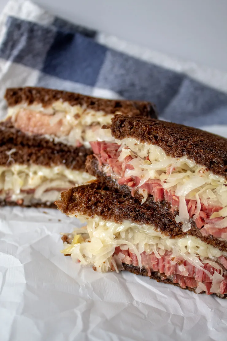 Reubens, two sandwiches, cut in half and stacked.