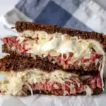 Reubens, grilled Reuben sandwich cut in half and stacked.