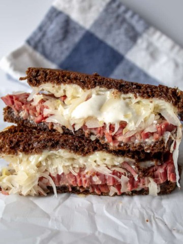 Reubens, grilled Reuben sandwich cut in half and stacked.