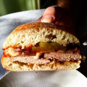 Grilled Pork Tenderloin Sandwich, holding sandwich to show filling
