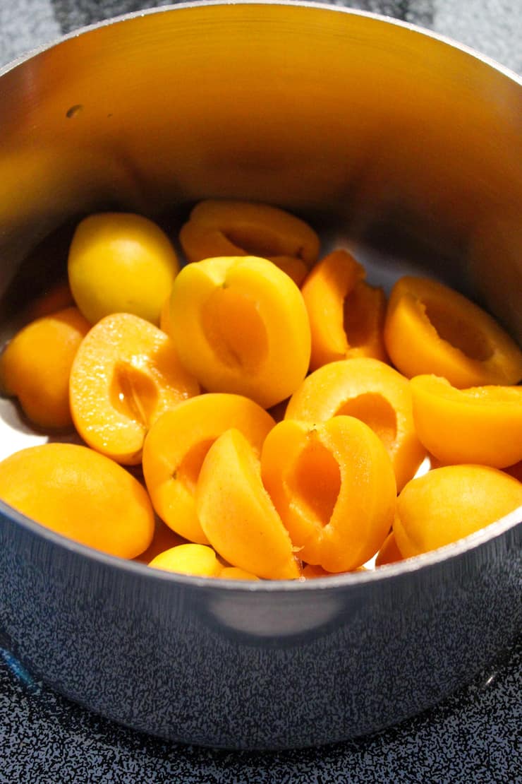 Apricots in pot with water.