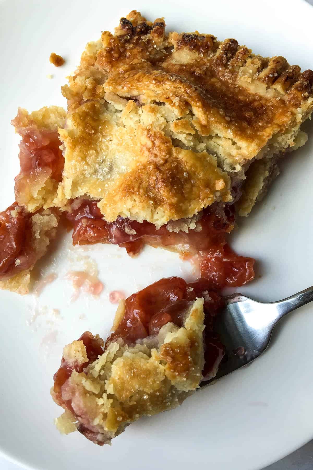 Cherry Pie on plate cut with a forkful.