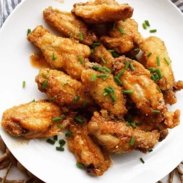 Wings on white plate with snipped chives.