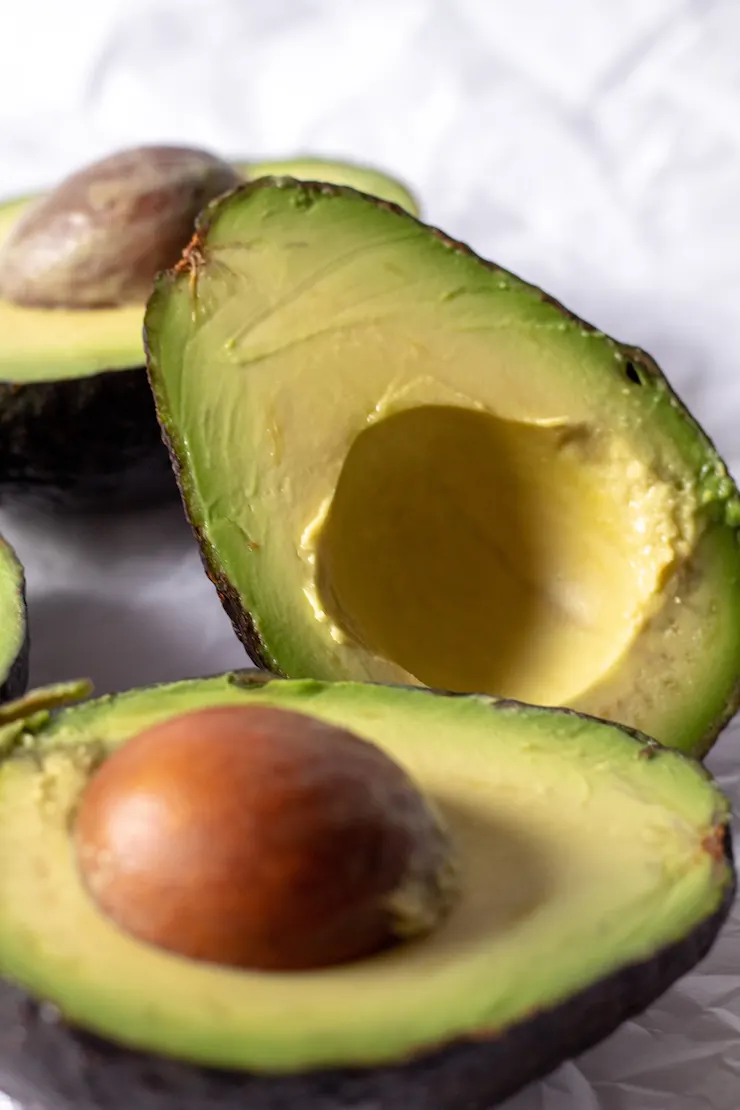 Close up of avocados cut in half.