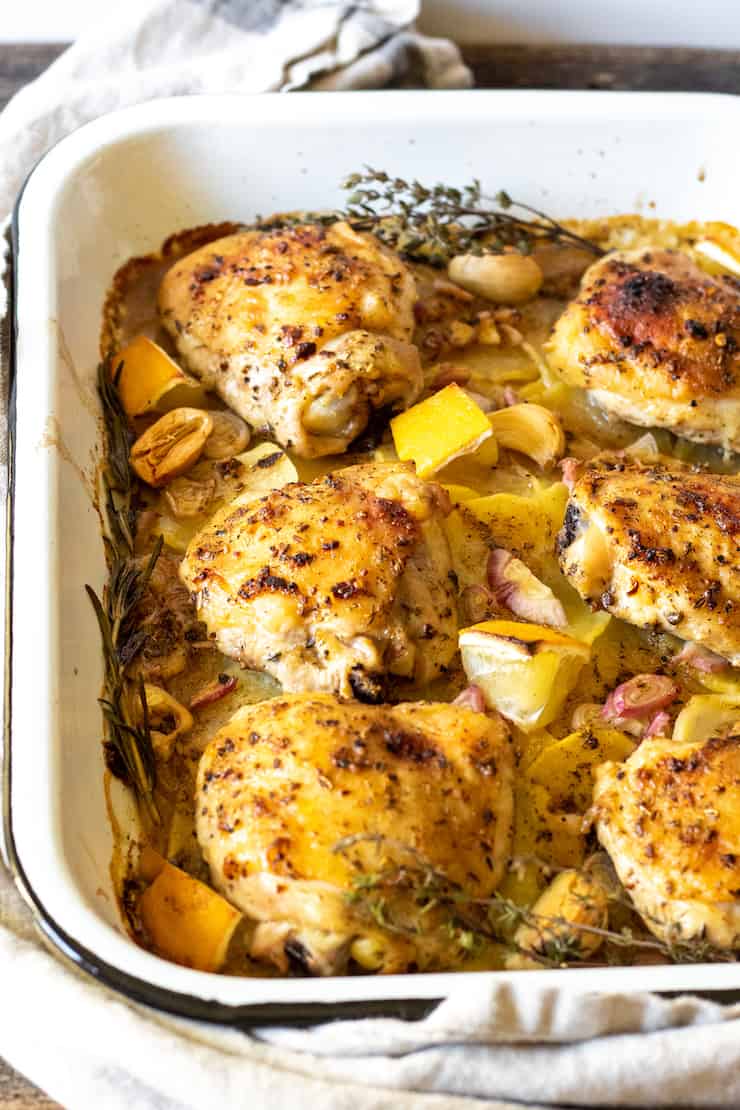 Close up of baked chicken and potatoes in pan.