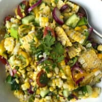 Grilled corn salad in serving bowl with spoon.