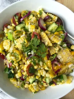 Grilled corn salad in serving bowl with spoon.
