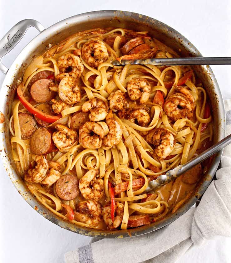 Creamy Cajun Shrimp Pasta in large skillet with tongs