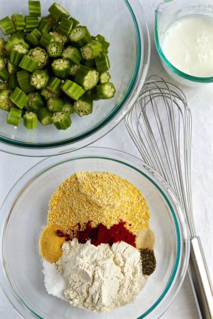 Ingredients in bowls for frying okra, seasoned cornmeal, cut up okra and buttermilk.