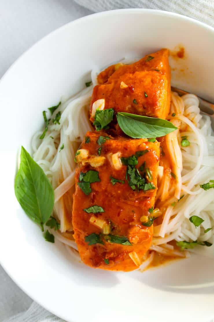 Plated coconut curry salmon over rice stick noodles.