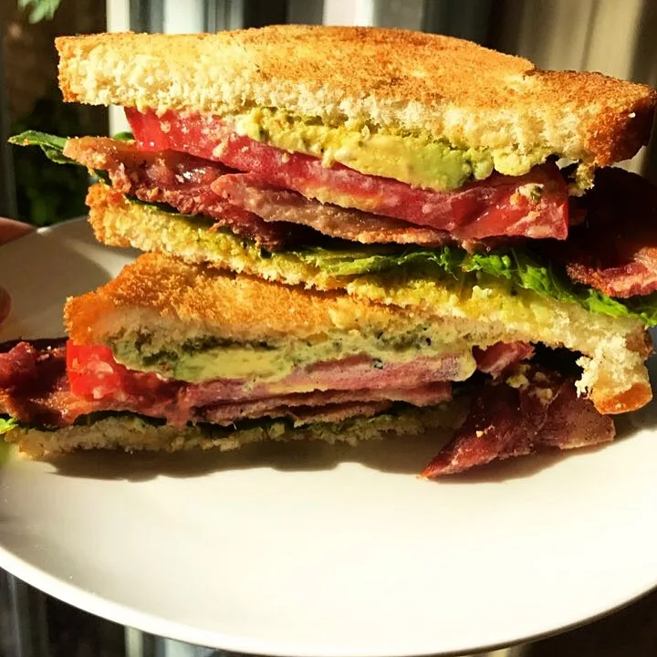 Stacked BLT sandwich with avocado and pesto mayo.