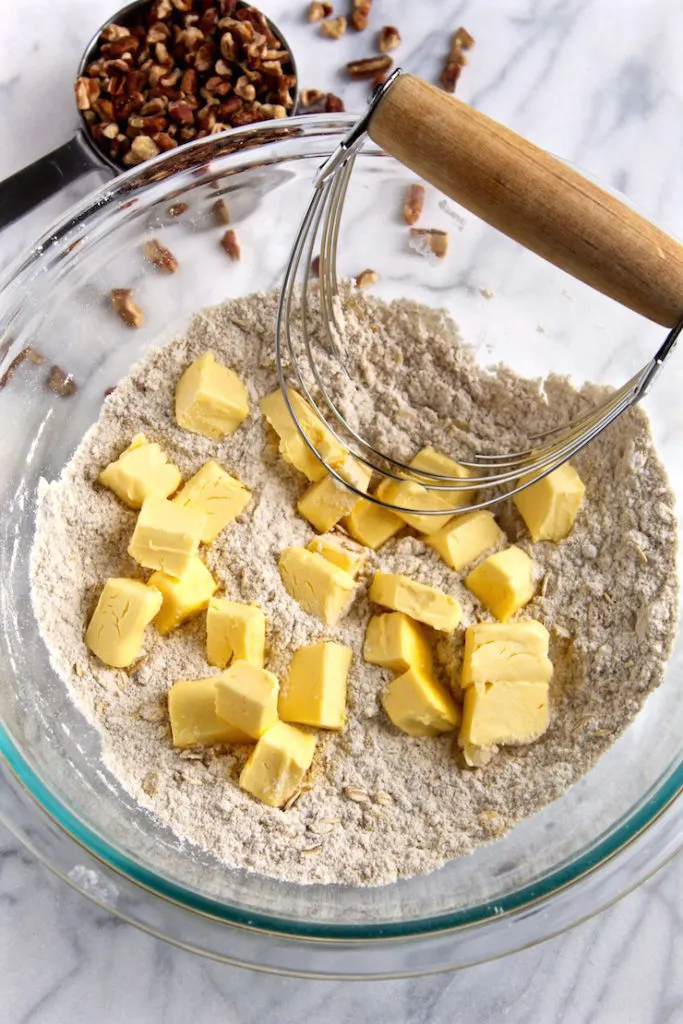 Cutting the butter into the dry ingredients with a pastry blender.