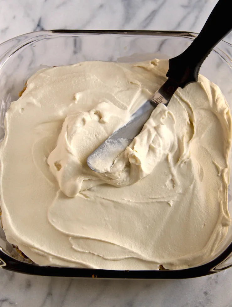 Spreading the layer of vanilla ice cream.