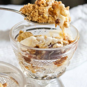 Close up of spoonful of crunch square dessert above serving dish.