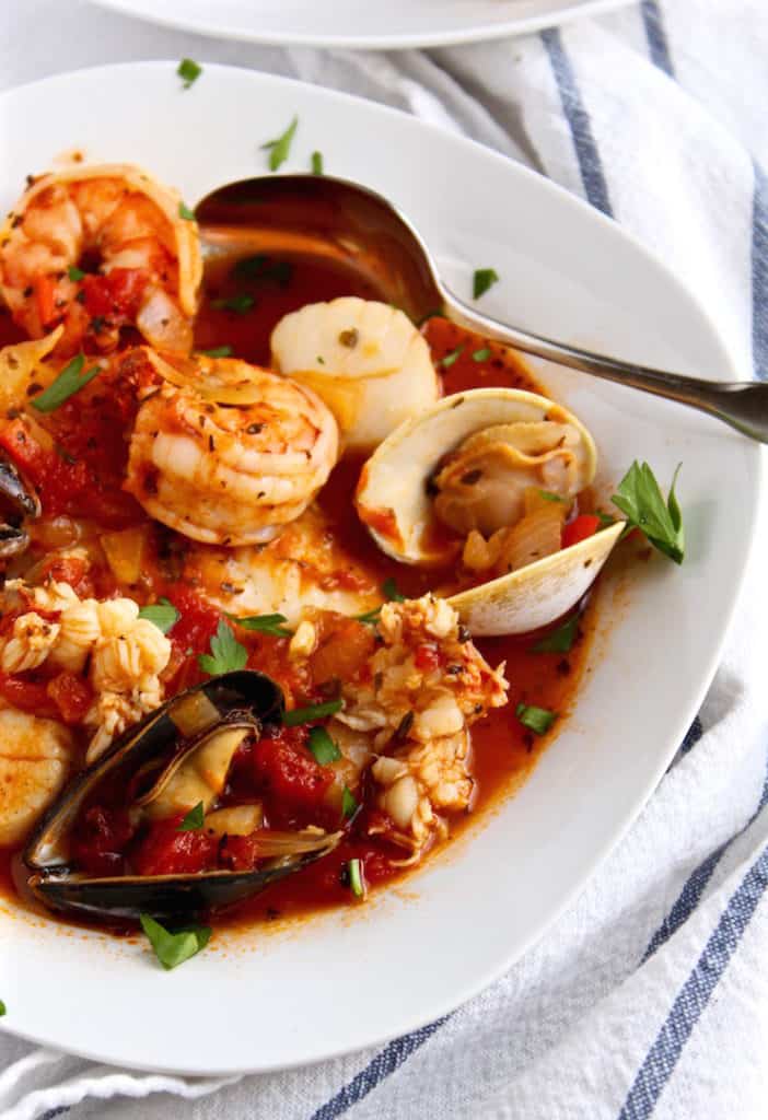 Classic Cioppino, close up in bowl with spoon.