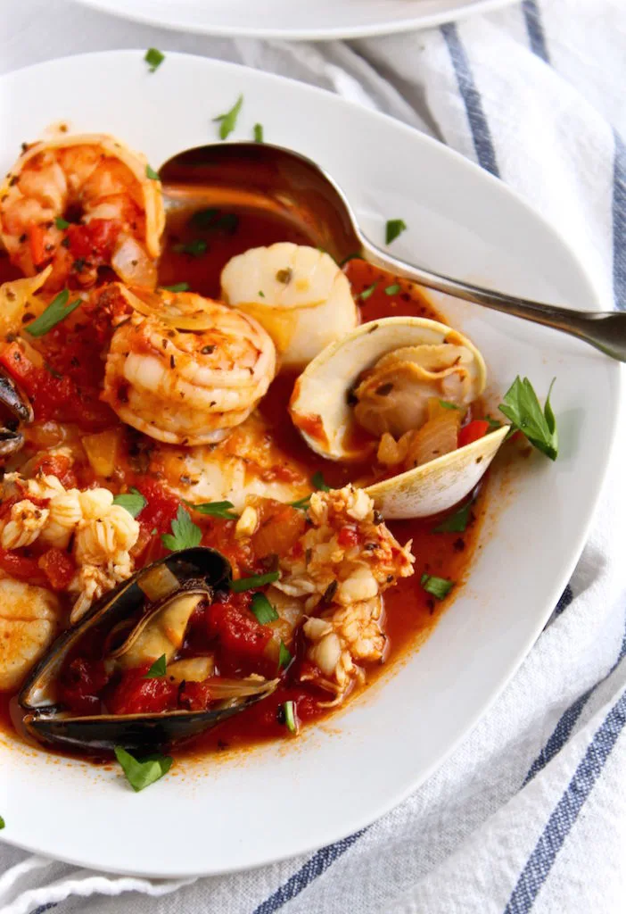Classic Cioppino, close up in bowl with spoon.