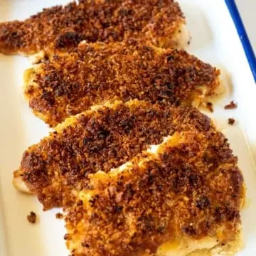 Baked chicken breasts displayed in enamelware pan.