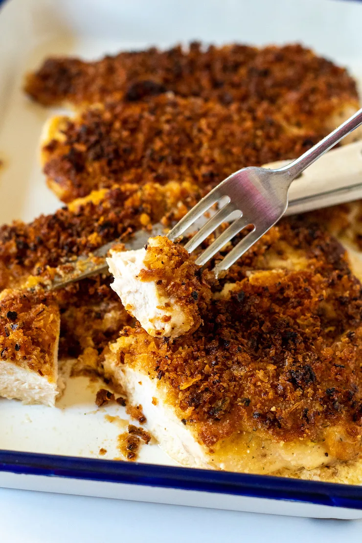 Cutting into chicken with knife and fork.