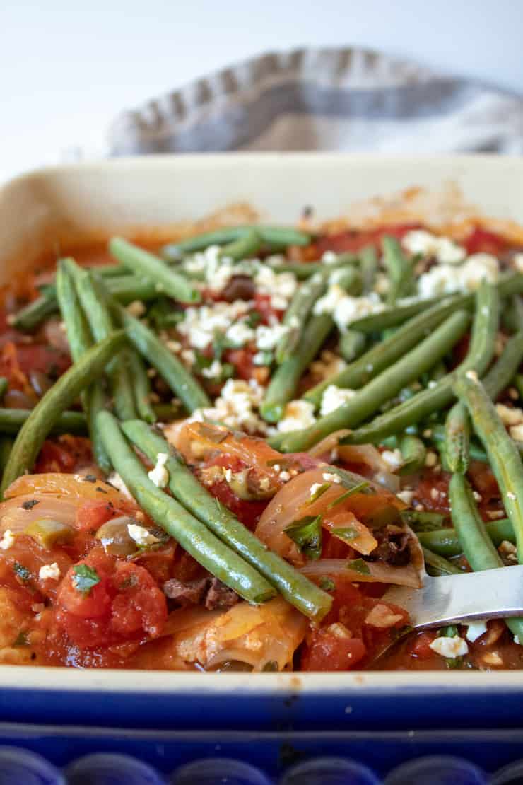 Mediterranean Baked Fish, in baking pan with spatula.