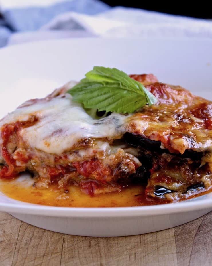 Eggplant Parmesan, serving of eggplant parmesan in dish with fresh basil