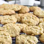 Oatmeal cookies on rack with glass of milk.