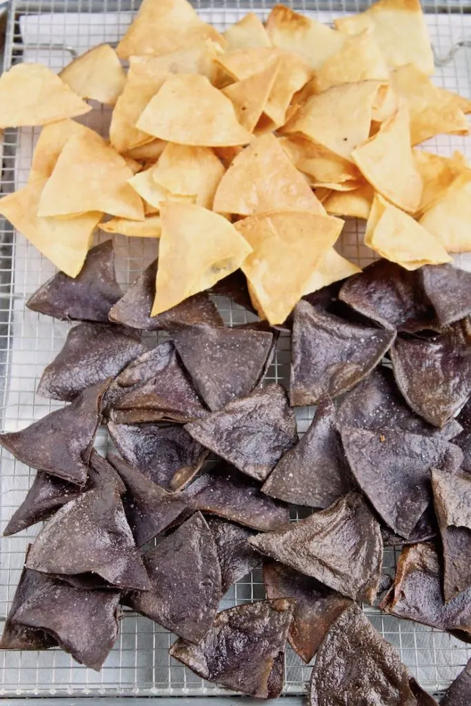 Homemade tortilla chips draining on wire rack.