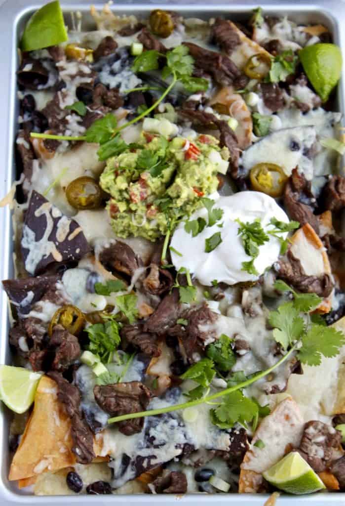 Nachos on sheet pan with all the toppings.