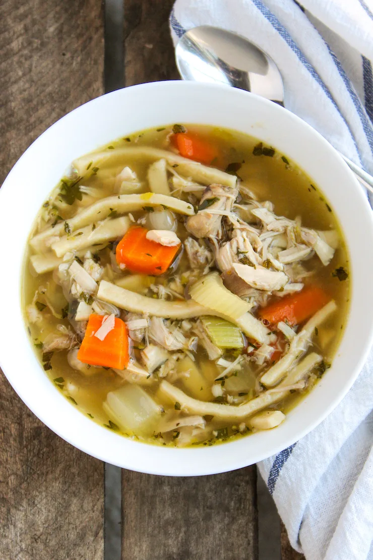 Turkey soup in white serving bowl.