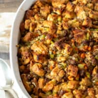 Finished baked stuffing in casserole dish with serving spoon.