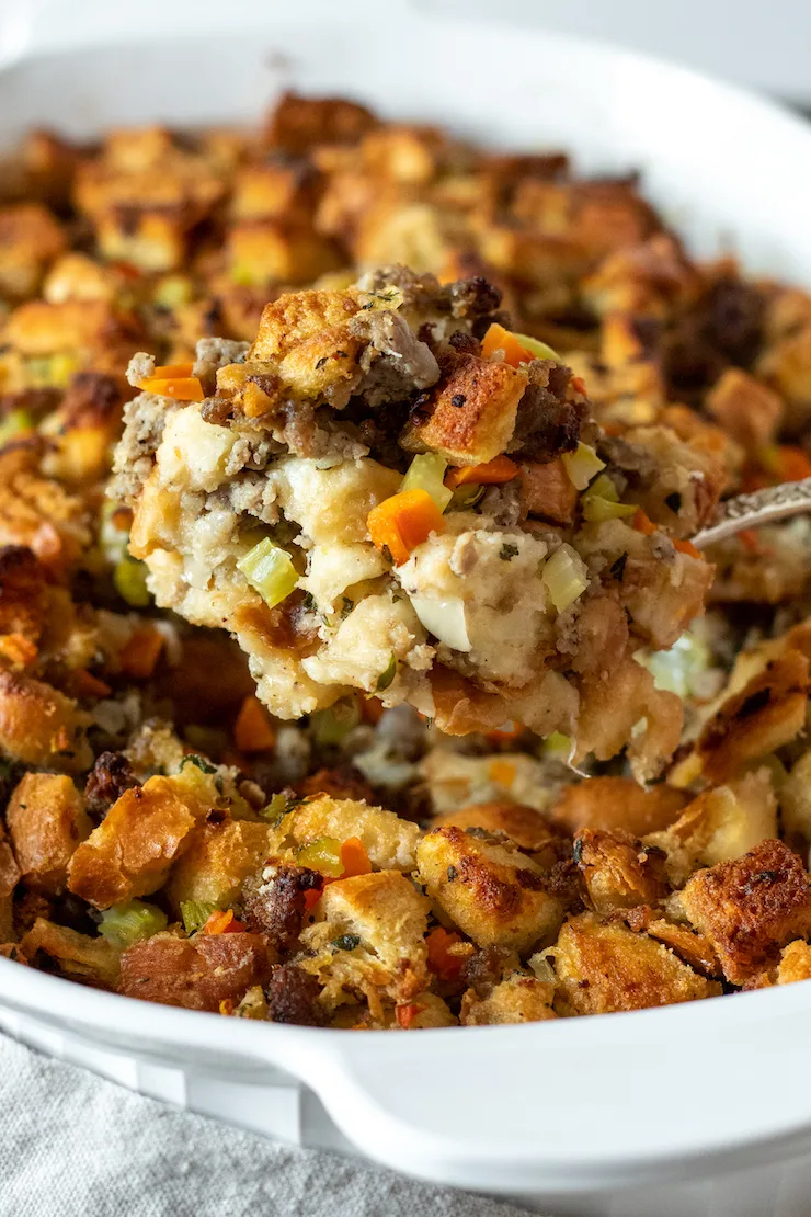Spoonful of old fashioned bread stuffing in casserole dish.