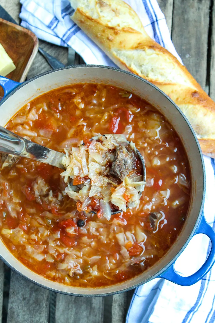 Overhead photo of soup pot with ladle full of soup.