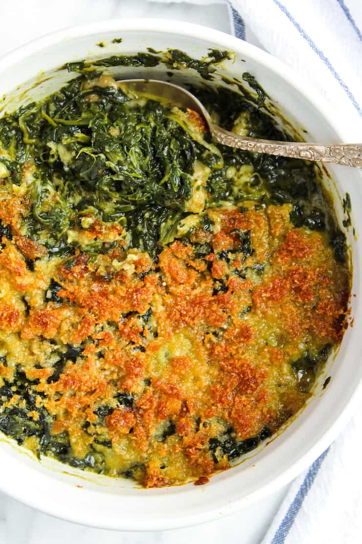 Spoon dipping into spinach casserole.